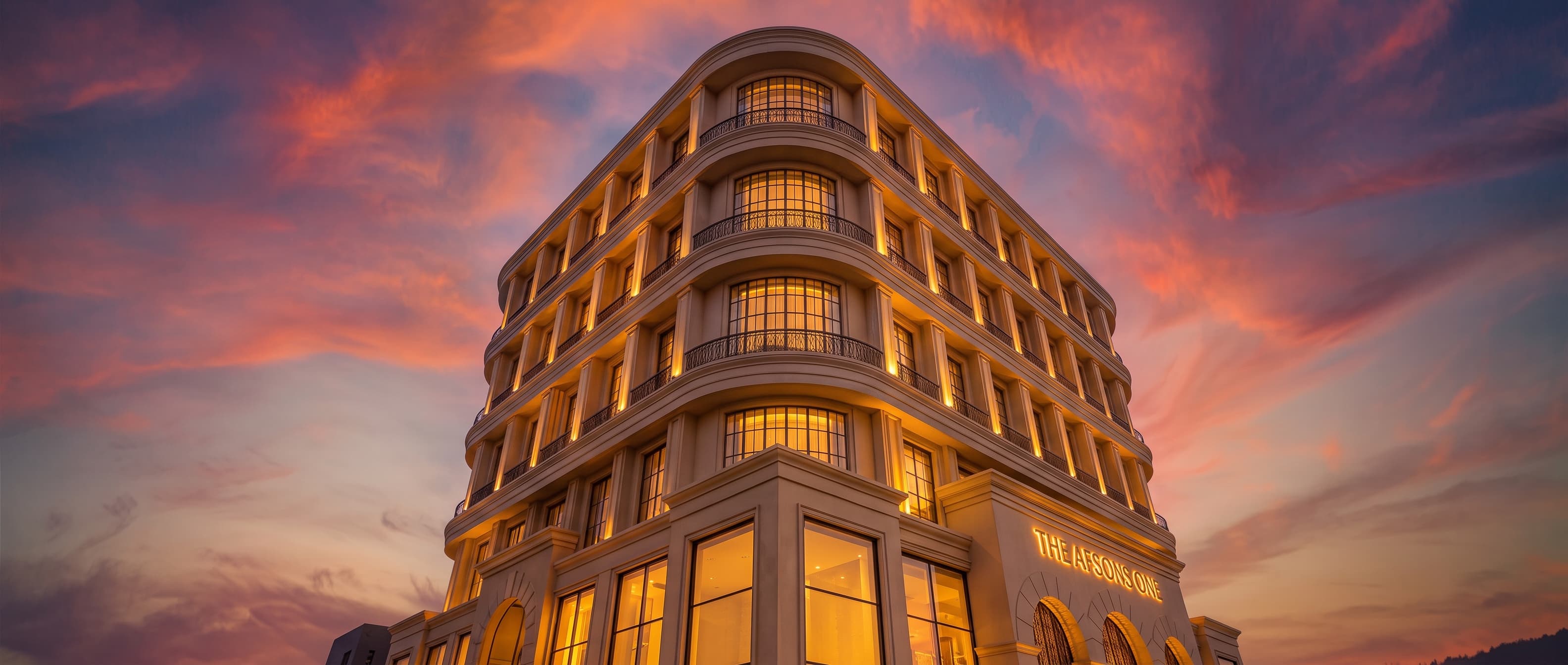 The Afsons One seen from below at sunset, its curved corner rising against a red sky