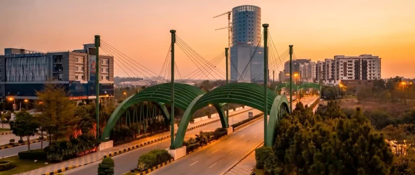 The Gulberg Greens entrance arches on the Islamabad Expressway at sunset